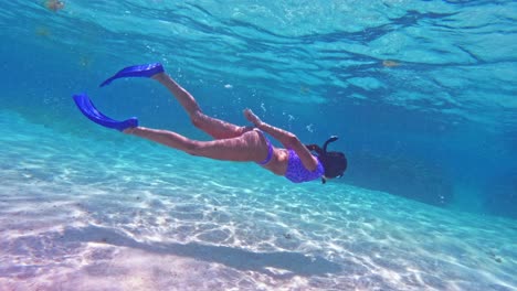 A-girl-snorkelling-over-white-sand-in-Caye-Caulker,-Belize