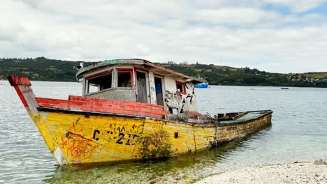 Truck-right-abandoned-fishing-boats-in-Dalcahue,-Chiloé-archipelago,-Chile