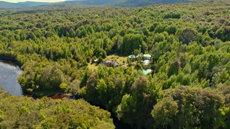 Aerial-orbit-of-the-lodge-in-tepuhueico-park,-forest-zone,-greenery-in-Chiloé,-Chile