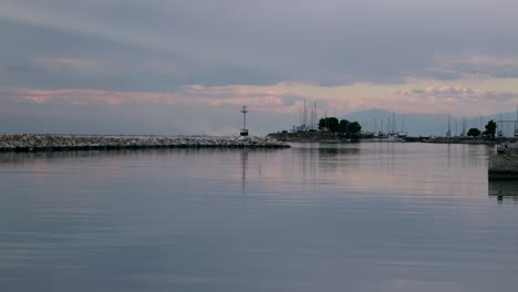 Small-port-during-cloudy-evening-with-breakwater-and-a-small-lighthouse