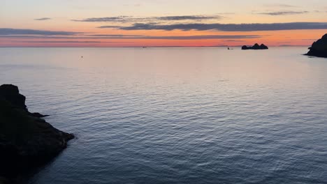 Sonnenuntergangshorizont-Des-Papageientaucher-Aussichtspunkts,-Heimaey,-Island-Mit-Vögeln,-Die-über-Die-Ruhige-Meeresküste-Fliegen