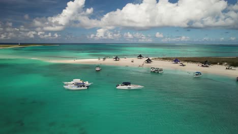 Los-roques-archipelago-with-clear-turquoise-waters,-boats,-and-sandy-beaches,-daylight,-aerial-view