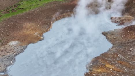 An-aerial-drone's-orbit-view-from-a-medium-altitude-of-Engjahver's-steam-lake-on-the-Reykjanes-Peninsula-in-Iceland