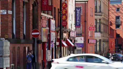 Daytime-view-of-Manchester's-Chinatown,-vibrant-signs-and-busy-street-scene