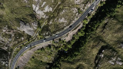 Top-down-view-of-cars-driving-through-Scotland's-Glencoe-Valley-on-a-sunny-day