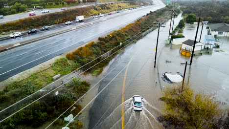 Drone-rises-above-cars-turning-around-after-seeing-flooded-frontage-road-blocking-path