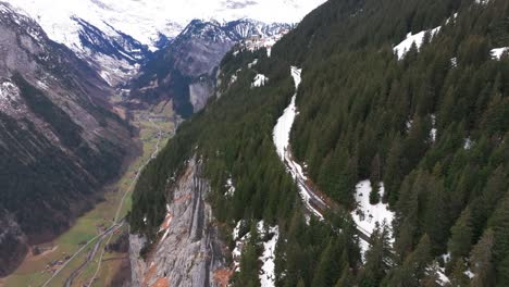 Railway-among-evergreen-forest-and-near-steep-Switzerland-mountain-edge