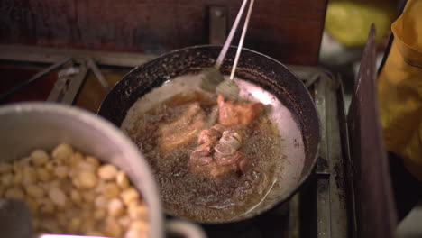 Ein-Echter-Einblick-In-Eine-Lokale-Küche-In-Cusco,-Peru,-Wo-Das-Traditionelle-„Chicharrón-De-Chancho“-Zubereitet-Wird,-Serviert-Mit-Peruanischem-Mais,-Bekannt-Als-„Choclo“.