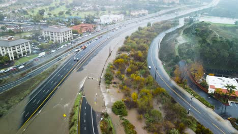 Heavy-torrential-downpours-floods-and-closes-off-highway-in-San-Diego-California,-aerial-overview