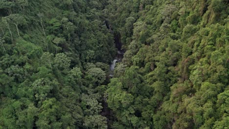 Aerial-flying-backwards-over-Jima-Falls-in-middle-of-lush-forest,-Dominican-Republic