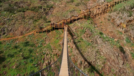 Crossing-a-suspension-bridge,-part-of-the-wooden-walkways-along-mountain-trails-in-Monchique