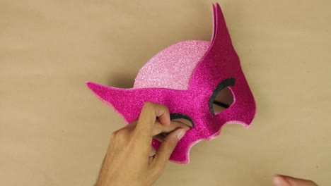 Hands-making-carnival-mask,-gluing-the-material-with-liquid-silicone