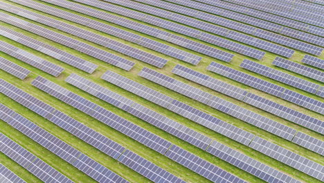 Huge-endless-solar-panel-array-in-a-flat-english-field,-aerial-footage-on-a-sunny-day
