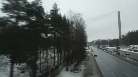 POV-from-train,-Scandinavian-winter-city-suburb-rolls-past-window