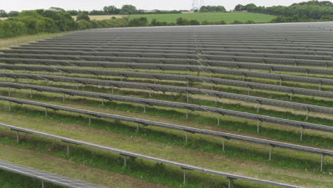 Solar-farm,-endless-rows-of-photovoltaic-panels-aerial-footage-in-english-countryside