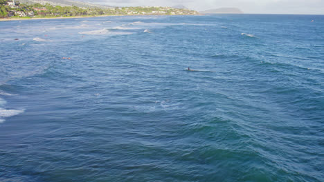 Kiteboarder-Und-Surfer-Tummeln-Sich-Auf-Der-Meeresoberfläche,-Während-Sie-Vor-Der-Küste-Der-Hawaii-Inseln-Oahu-Auf-Die-Perfekte-Welle-Warten