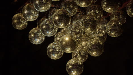 Shiny-mirror-balls-in-darkness-transition-from-gold-to-silver-light