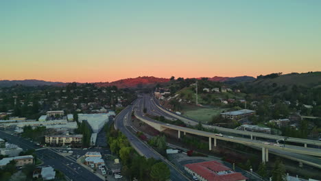 Aerial-drone-shot-over-downtown-Walnut-Creek,-with-the-BART-and-highway-680-surrounded-by-houses-in-California,-USA-during-evening-time