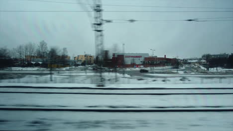 Pov-Aus-Dem-Fenster:-Zug-Fährt-An-Einem-Verschneiten-Wintertag-Durch-Die-Vororte-Der-Stadt