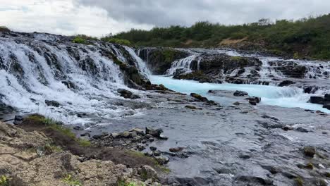 Bruarfoss-Kaskadierender-Blauer-Wasserfall,-Der-Den-Felsigen-Strom-Des-Isländischen-Gletschers-Hinunterfließt