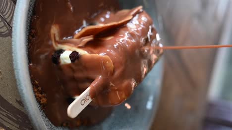 Vertical-Footage:-Pouring-caramel-sauce-on-the-baby-dynamite-dessert,-which-is-the-combination-of-chocolate-and-ice-cream
