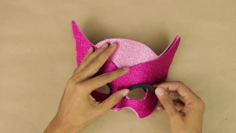 Hands-making-Owlette-mask-pink-diamond-foam-glued-for-carnival
