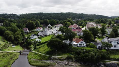 Ljungskile-town-with-traditional-Swedish-houses-near-a-river,-cloudy-day,-aerial-view
