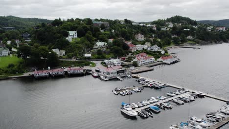 Ljungskile-small-boat-marina-with-boats-docked-in-slips-on-overcast-day,-Sweden,-Aerial