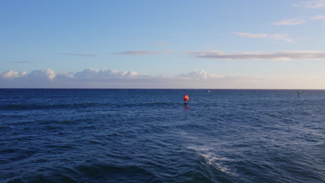 Ein-Kiteboarder-Gleitet-über-Das-Blaue-Wasser-Des-Pazifischen-Ozeans,-Während-Die-Weißen-Wellen-An-Die-Küste-Hawaiis-Krachen
