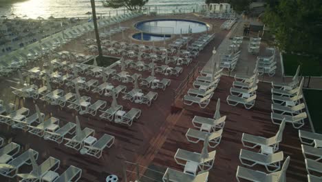 Filmischer-Drohnenclip,-Der-Sich-über-Einen-Swimmingpool-Und-Liegestühle-In-Einem-Luxuriösen-Hotelresort-Auf-Mallorca,-Spanien,-Lehnt