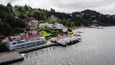 Traditional-Swedish-bathhouse-by-the-sea-in-Ljungskile-with-surrounding-homes,-aerial-view