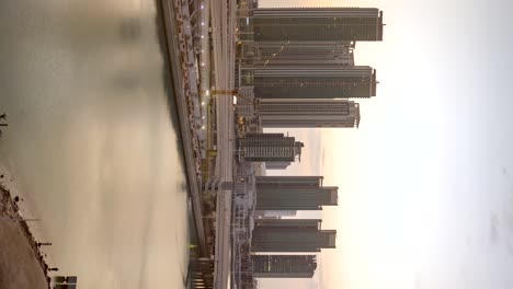 Abu-Dhabi,-Vereinigte-Arabische-Emirate,-Skyline-Der-Stadt,-Goldener-Sonnenaufgang,-Zeitraffer-–-Vertikale-Ausrichtung
