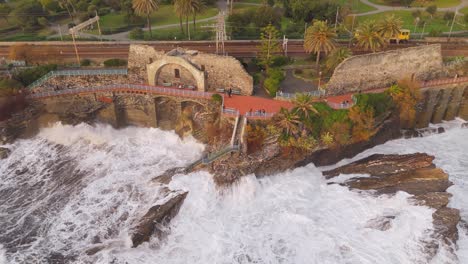 Waves-crashing-against-cliffs-by-the-nervi-walkway-in-genoa,-italy,-aerial-view