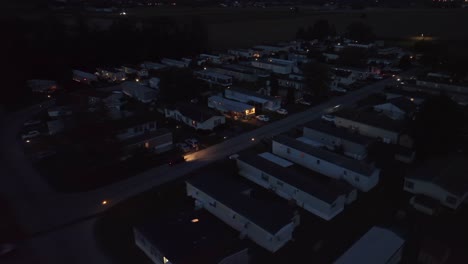 Die-Nacht-Bricht-über-Einen-Wohnmobilpark-Mit-Beleuchteten-Fenstern-Und-Ruhigen-Straßen-Herein