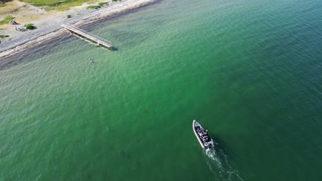 Drone-footage-of-motor-boat-sailing-towards-the-beach-to-moor-at-a-jetty