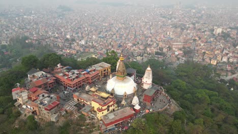 aerial-drone-shot-of-monkey-temple-In-Kathmandu,-Nepal-at-the-base-of-the-Himalayas