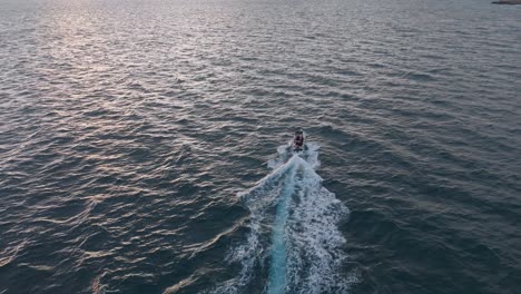 Ein-Boot,-Das-In-Der-Abenddämmerung-Durch-Die-Ruhigen-Gewässer-Vor-Der-Küste-Von-Nervi,-Genua,-Italien-Fährt,-Luftaufnahme