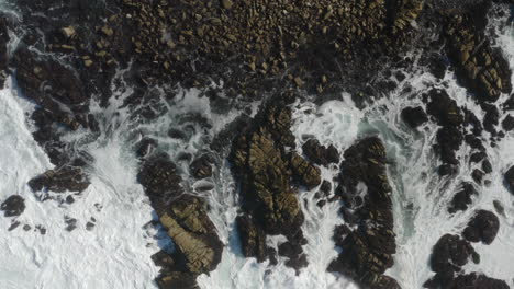 4K-cinematic-overhead-of-waves-crashing-on-shoreline-rocks-in-California