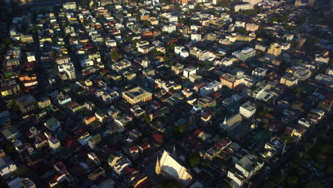 Aerial-overview-of-sunlit-dwellings-in-the-Olympia-Barangay-in-Manila,-Philippines