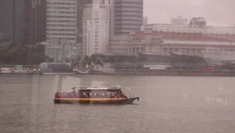 Boot-Schwimmt-Im-Hafen-Von-Marina-Bay-Sands-Im-Hochmodernen-Stadtbild-Von-Singapur,-Entlang-Der-Marina-Bay