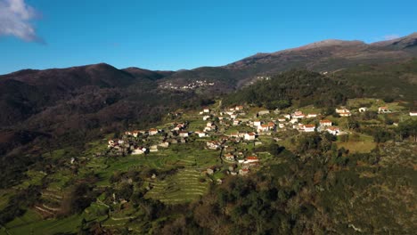 Panoramic-aerial-of-old-village-of-Soajo-on-mountainside-in-Arcos-de-Valdevez-Minho-Portugal,aerial-establish