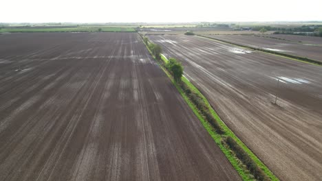 Drone-footage-flying-over-newly-ploughed-farmer's-fields-in-North-Yorkshire,-UK