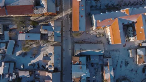 Aerial-establishing-view-of-Kuldiga-Old-Town-,-houses-with-red-roof-tiles,-Liepajas-street,-sunny-winter-day,-travel-destination,-wide-drone-birdseye-shot-moving-forward
