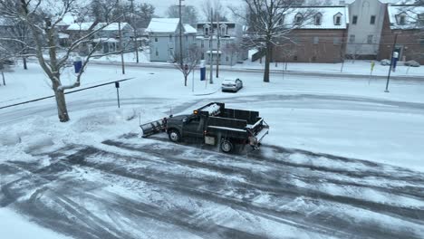 Pickup-truck-with-dump-bed-and-snow-plow-clearing-snow-covered-parking-lot