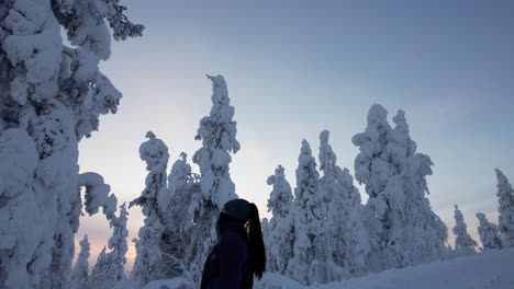 Girl-Walking-Amongst-Massive-Snow-Covered-Trees-in-Lapland,-Finland,-Arctic-Circle