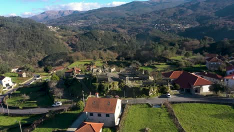 Soajo-village-granaries-on-hilltop-overlooking-town-below,-aerial-orbit-in-Arcos-de-Valdevez-Portugal