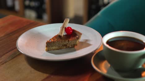 Stück-Kürbis-Brownie-Sahnekuchen-Dessert-Mit-Zimt-Und-Kirsche-Zusammen-Mit-Einer-Tasse-Kaffee-Auf-Dem-Tisch-In-Einem-Café