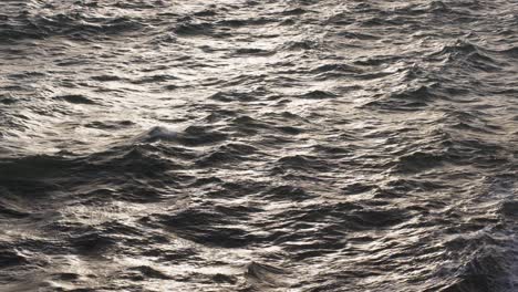 Sunlight-reflecting-on-the-rippling-surface-of-a-vast,-dark-ocean,-capturing-the-endless-motion-of-water