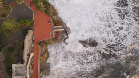 The-rugged-coastline-in-nervi,-genoa-with-waves-crashing-against-the-shore,-aerial-view