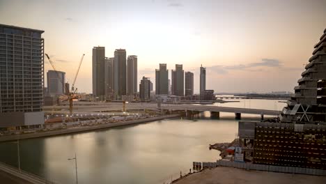 Abu-Dhabi,-Horizonte-De-La-Ciudad-De-Los-Emiratos-árabes-Unidos-Durante-Un-Amanecer-Dorado---Lapso-De-Tiempo,-Paisaje-Nublado,-Isla-Al-Reem,-Al-Maryah